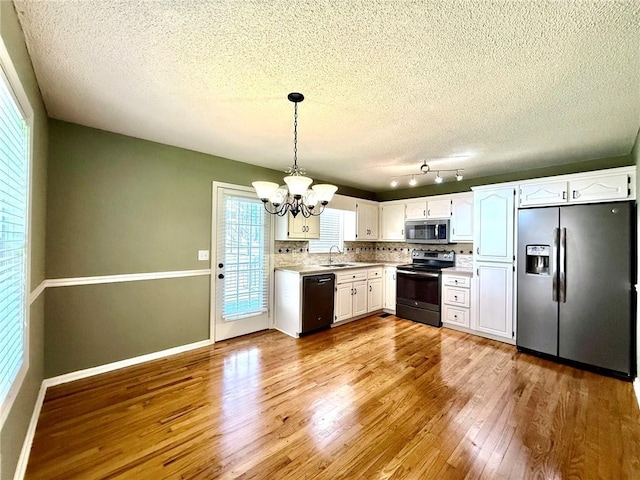 kitchen featuring a chandelier, light countertops, wood finished floors, white cabinets, and stainless steel appliances