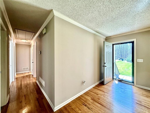 foyer entrance with a textured ceiling, wood finished floors, and ornamental molding