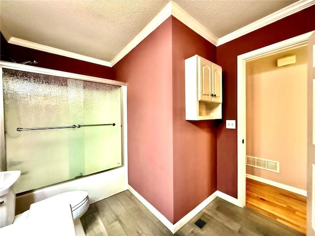 full bathroom featuring visible vents, combined bath / shower with glass door, toilet, and wood finished floors