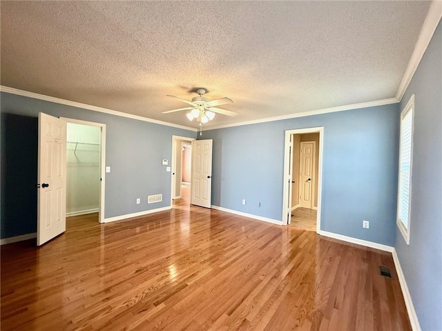 unfurnished bedroom with crown molding, wood finished floors, and baseboards