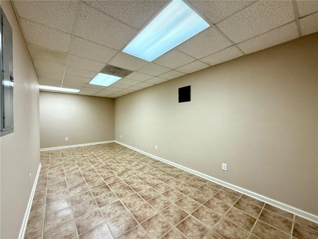 finished basement featuring a drop ceiling and baseboards