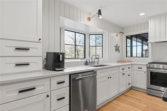 kitchen with white cabinetry, plenty of natural light, appliances with stainless steel finishes, and a sink