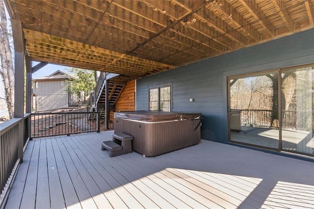 deck with stairway and a hot tub