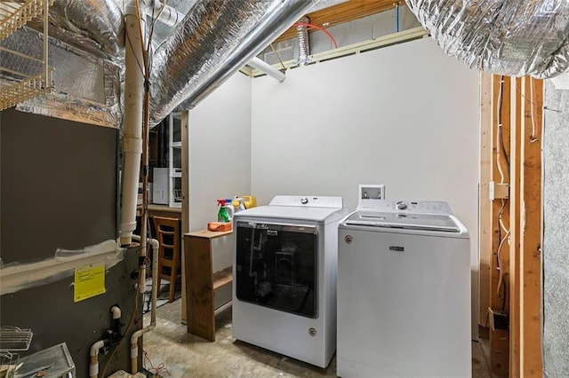 laundry room with heating unit, laundry area, and washer and clothes dryer