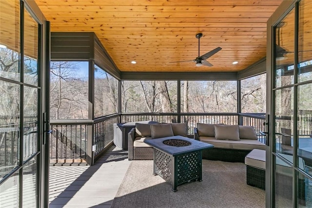 sunroom / solarium with lofted ceiling, wood ceiling, and ceiling fan