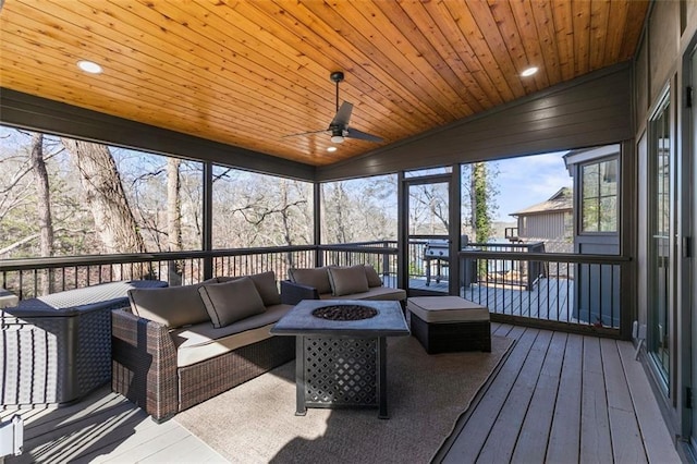 sunroom with lofted ceiling, wooden ceiling, and ceiling fan