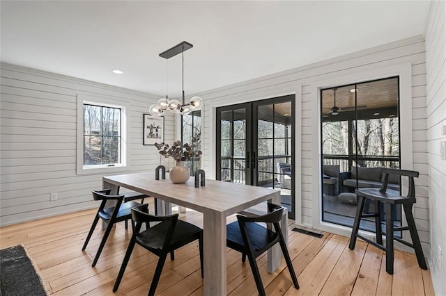 dining room with french doors, an inviting chandelier, and light wood-style floors