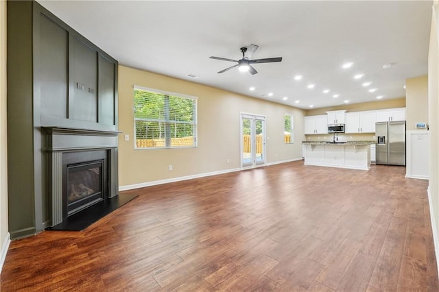 unfurnished living room with ceiling fan and hardwood / wood-style flooring