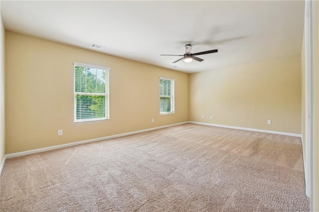 empty room featuring ceiling fan and light colored carpet