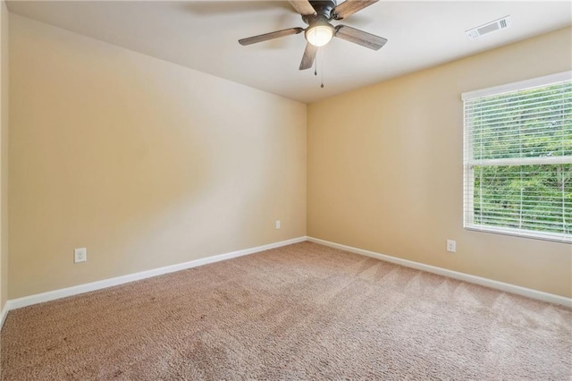 carpeted spare room featuring ceiling fan