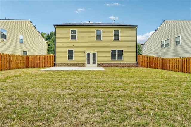 rear view of property featuring a lawn and a patio