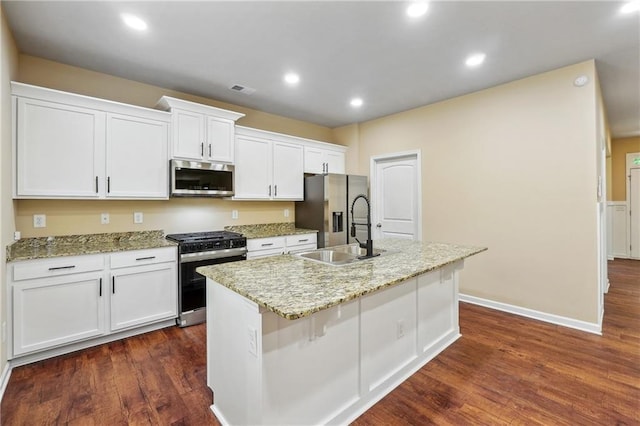 kitchen with dark wood-type flooring, white cabinetry, stainless steel appliances, sink, and a center island with sink