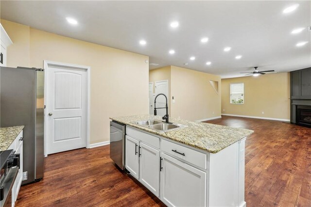 kitchen with an island with sink, ceiling fan, appliances with stainless steel finishes, white cabinets, and sink