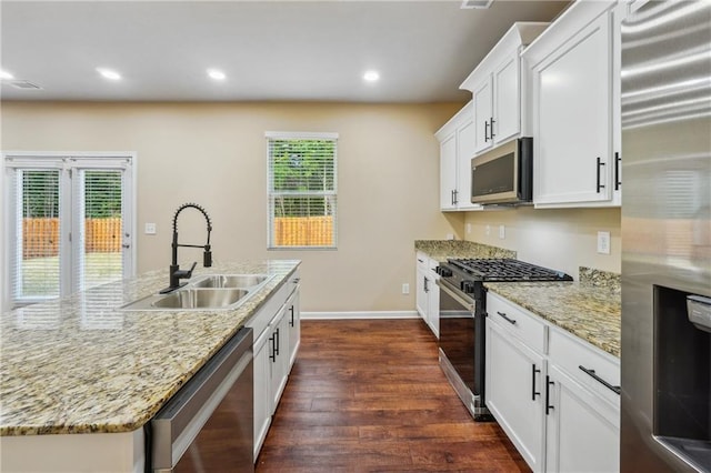 kitchen with dark hardwood / wood-style floors, sink, a kitchen island with sink, stainless steel appliances, and white cabinets