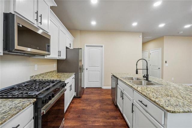 kitchen with sink, white cabinetry, a kitchen island with sink, dark wood-type flooring, and appliances with stainless steel finishes