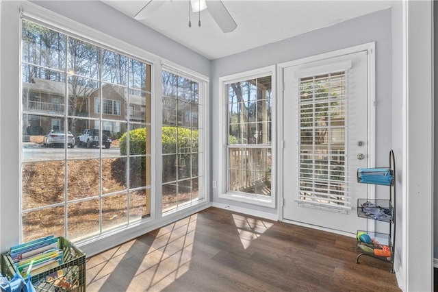 unfurnished sunroom featuring a ceiling fan