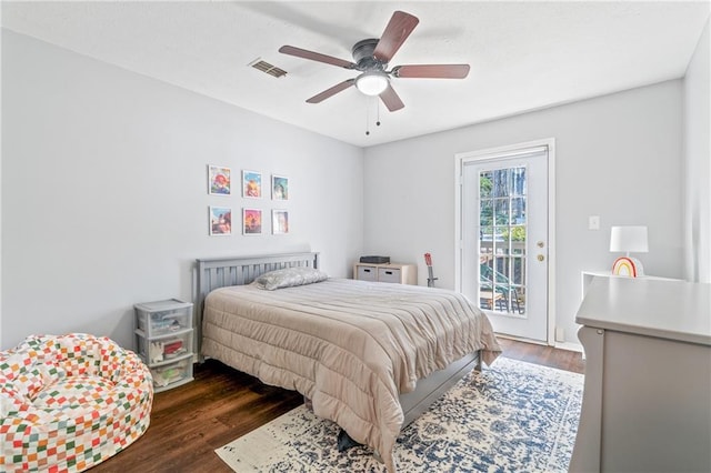 bedroom featuring access to outside, wood finished floors, visible vents, and a ceiling fan