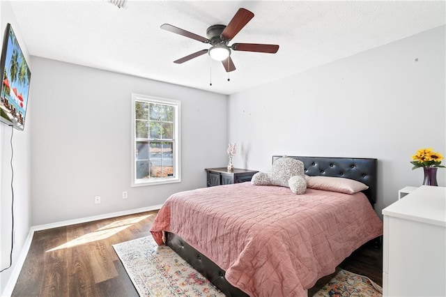 bedroom with a textured ceiling, ceiling fan, wood finished floors, and baseboards