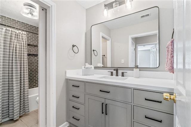 bathroom with toilet, shower / tub combo, visible vents, and vanity