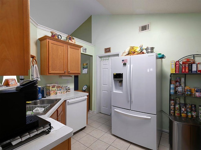 37 Montana Dr, Cedartown, GA 30125 - kitchen featuring white appliances, light tile patterned floors, light countertops, brown cabinetry, and vaulted ceiling