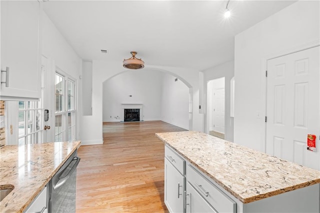 kitchen featuring light wood-style floors, dishwasher, white cabinets, and a center island