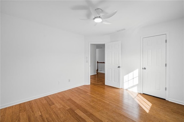 unfurnished bedroom with visible vents, a ceiling fan, baseboards, and wood finished floors