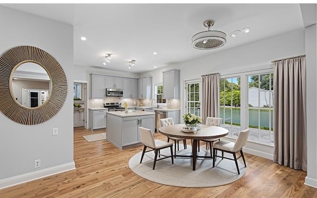 dining space with recessed lighting, light wood-type flooring, and baseboards