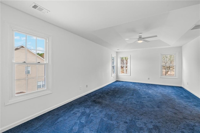 spare room featuring visible vents, a raised ceiling, and baseboards