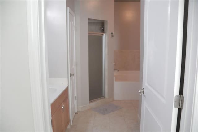 bathroom featuring tile patterned flooring, vanity, and separate shower and tub