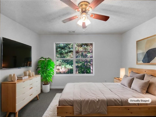 carpeted bedroom with a textured ceiling and ceiling fan