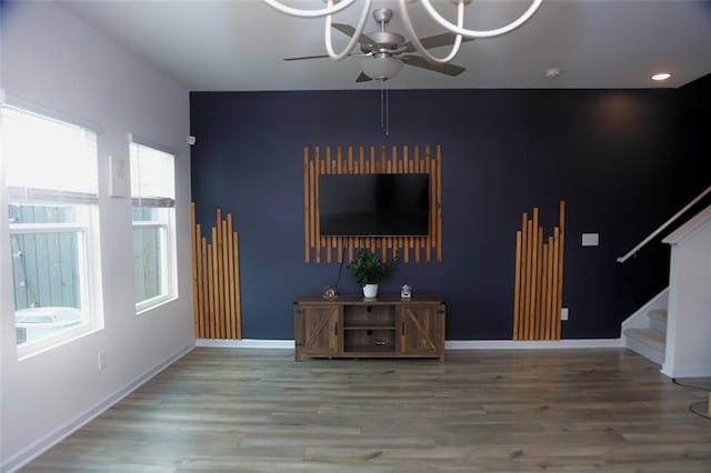 living room featuring hardwood / wood-style floors, ceiling fan with notable chandelier, and a wealth of natural light