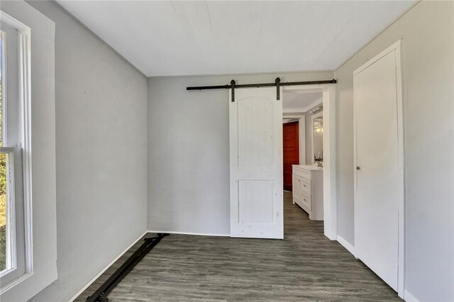 empty room featuring dark hardwood / wood-style flooring and a barn door