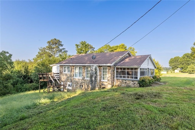 back of property with a yard and a sunroom