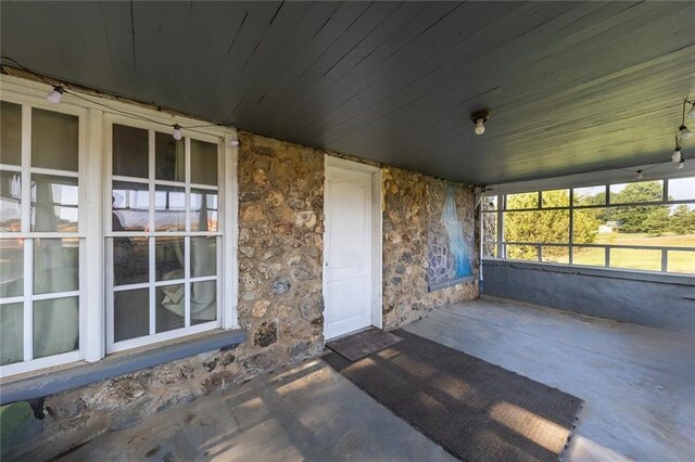 unfurnished sunroom with wooden ceiling