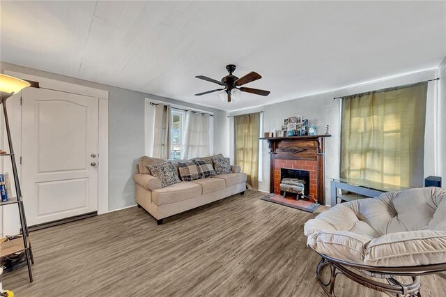 living room featuring ceiling fan, a fireplace, and light hardwood / wood-style flooring