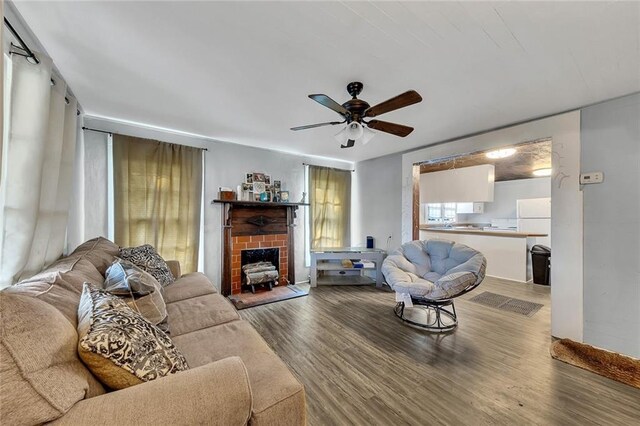 living room with a fireplace, wood-type flooring, and ceiling fan