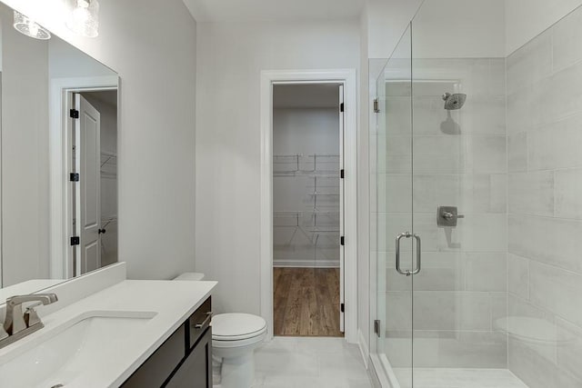 bathroom featuring an enclosed shower, vanity, and toilet