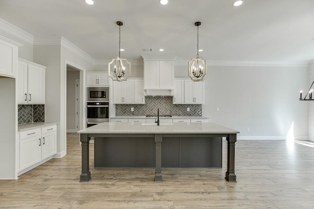 kitchen featuring white cabinets, an inviting chandelier, stainless steel appliances, and pendant lighting