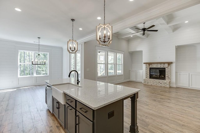 kitchen with light hardwood / wood-style floors, sink, light stone counters, beam ceiling, and coffered ceiling