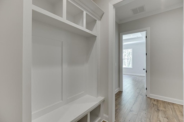 mudroom with crown molding and light hardwood / wood-style flooring