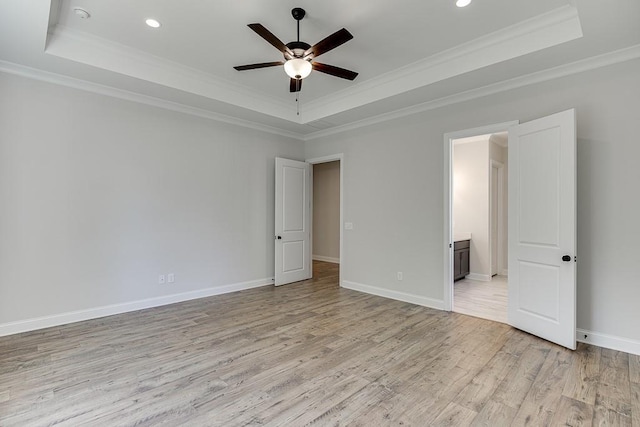 unfurnished room with crown molding, light hardwood / wood-style floors, and a raised ceiling