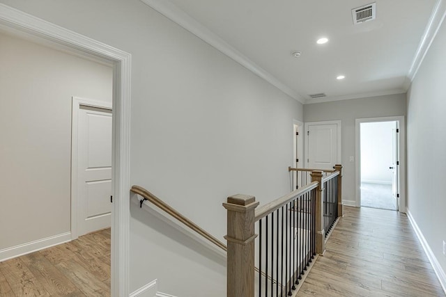 corridor featuring crown molding and light hardwood / wood-style floors