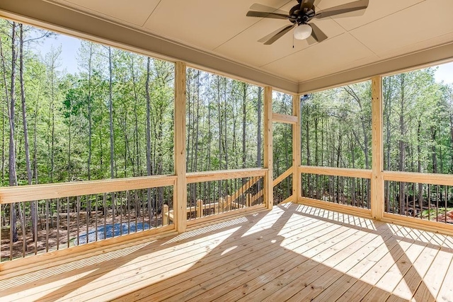 unfurnished sunroom with ceiling fan