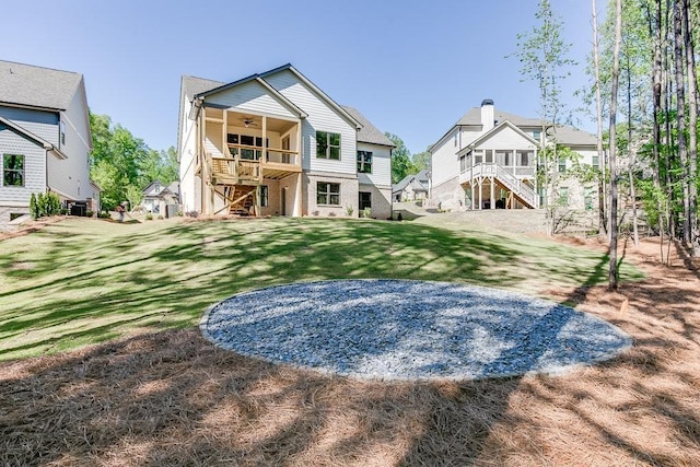 back of house featuring ceiling fan, central AC unit, and a lawn