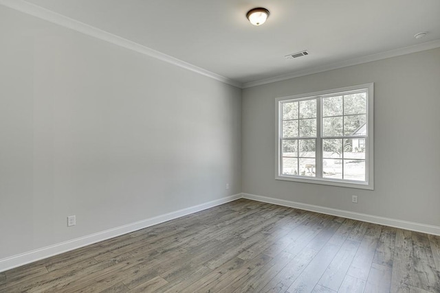 spare room featuring crown molding and hardwood / wood-style flooring