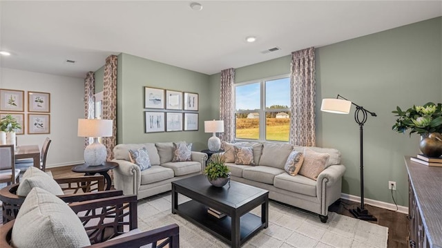 living room with baseboards, visible vents, light wood-style flooring, and recessed lighting