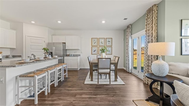 dining area with baseboards, dark wood-style flooring, and recessed lighting