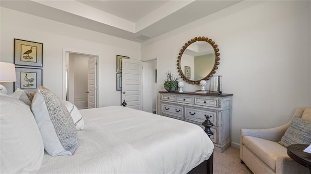 bedroom with ensuite bathroom and carpet floors