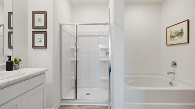 bathroom with a bathing tub, a shower stall, and vanity