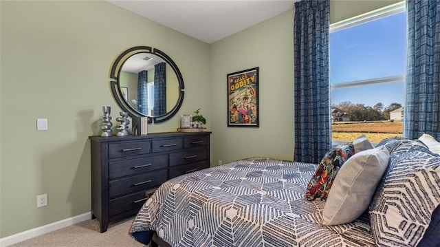 bedroom featuring light carpet and baseboards